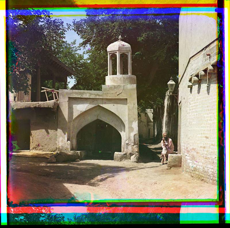 man_sitting_in_courtyard._arched_tower_in_background.jpg