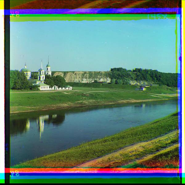 religious_buildings_and_bell_towers_near_waterway_cliff_in_background.jpg