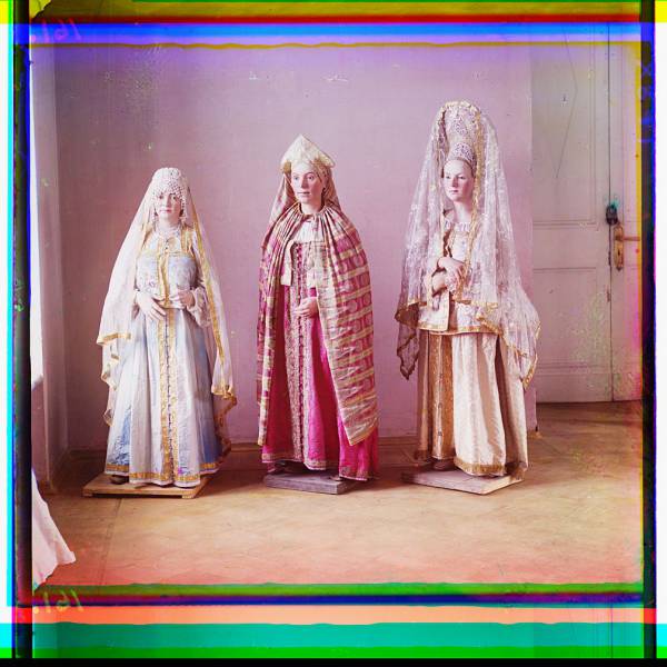 three_mannequins_of_women_in_elaborate_dress_on_wooden_stands.jpg