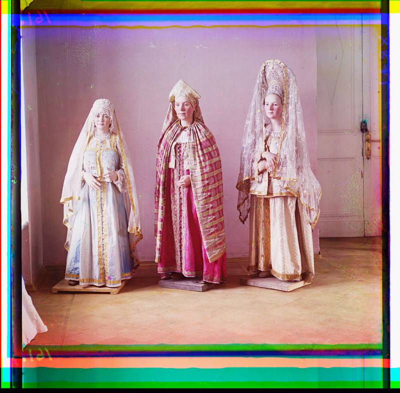 three_mannequins_of_women_in_elaborate_dress_on_wooden_stands.jpg