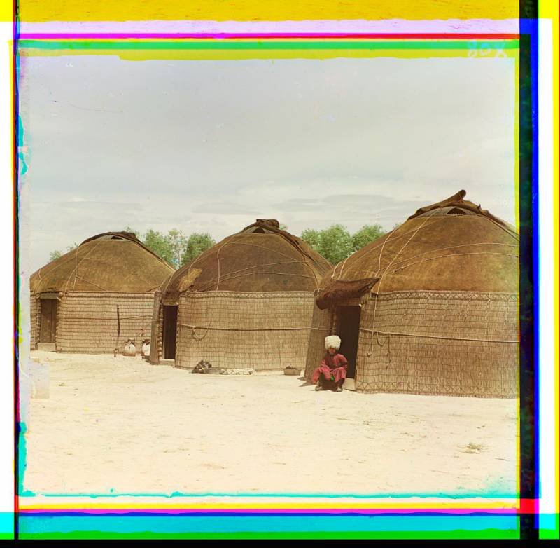 three_yurts_man_seated_in_doorway_of_yurt_in_foreground.jpg