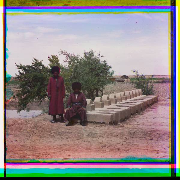 two_men_near_stone_structure_yurt_in_background.jpg