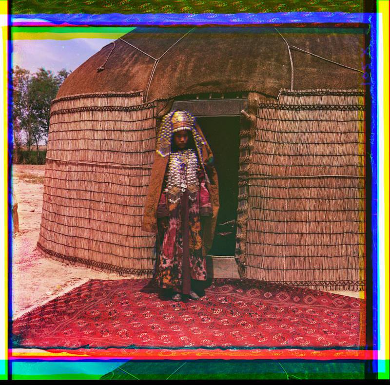 woman_in_traditional_dress_and_jewelry_standing_on_rug_in_front_of_yurt..jpg
